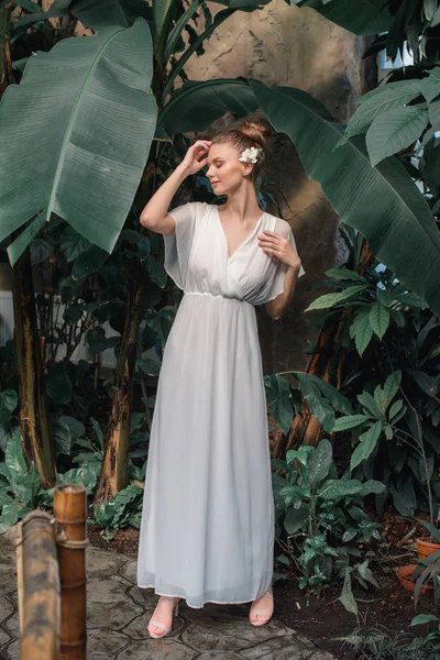 Bonita Jovem Mulher Vestido Branco Com Flor Cabelo Posando Jardim — Fotos gratuitas