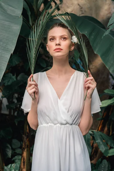 Stijlvolle Meisje Witte Zomerjurk Poseren Met Tropische Palmbladeren — Stockfoto