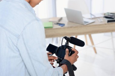 Afrika kökenli Amerikalı gencin vlog evde çekim için dijital kamera tutarak Resim kırpılmış