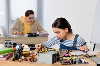 teenagers studying and fixing computer motherboard at home clipart