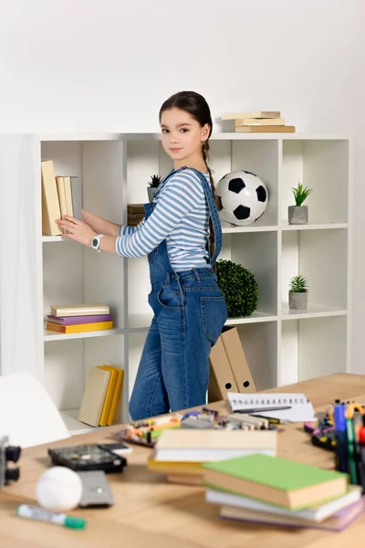 Adorable Niño Preadolescente Poniendo Libros Estante Mirando Cámara Casa — Foto de Stock