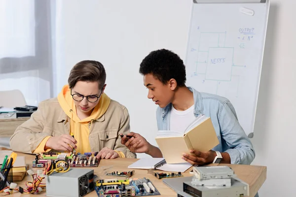 Multiculturele Tiener Jongens Studeren Reparatie Van Moederbord Van Computer Thuis — Gratis stockfoto