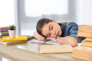 evde kitap üzerinde uyuyan sevimli varoluş çocuk