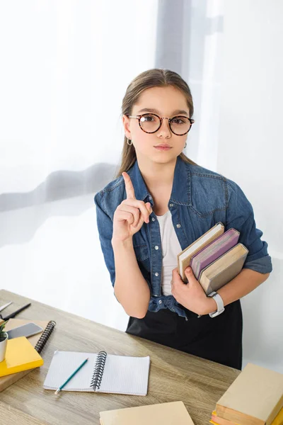 Bedårande Preteen Barn Visar Ett Finger Och Hålla Böcker Hemma — Stockfoto