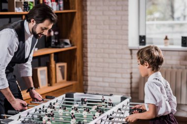 yakışıklı sakallı baba ve masa futbolu oynayan küçük oğul