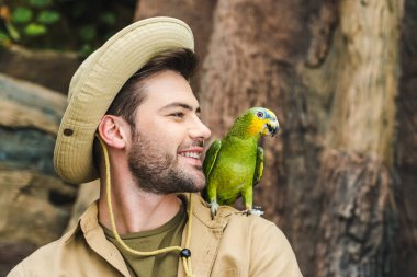 yakışıklı delikanlı ile omuz ormanda papağan
