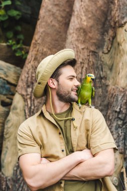 yakışıklı delikanlı ile omuz ve çapraz orman kollarında papağan