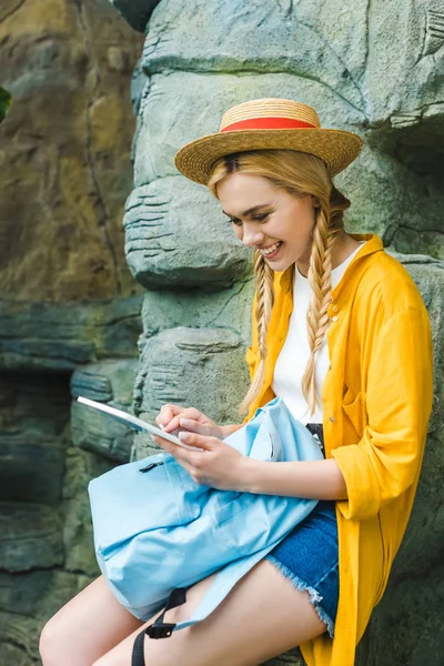 Smiling Young Woman Straw Hat Using Tablet While Sitting Rocks — Stock Photo, Image