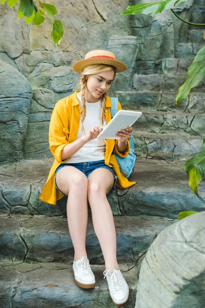 Όμορφη Νεαρή Γυναίκα Ψάθινο Καπέλο Χρησιμοποιώντας Tablet Καθμένος Πέτρινη Σκάλα — Δωρεάν Φωτογραφία
