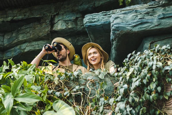 Bottom View Excited Young Couple Safari Suits Binoculars Cliff Jungle — Stock Photo, Image