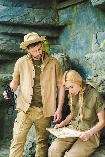 active young couple in safari suits trying to navigate in jungle