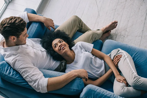 Pretty Multiracial Couple Hugging Lying Sofa — Stock Photo, Image