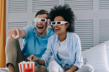 Patlamış Mısır ile evde film izlerken anaglif bardaklarda çift gülüyor
