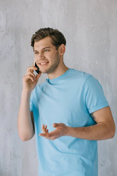 Young Man Talking Phone Gray Wall — Free Stock Photo