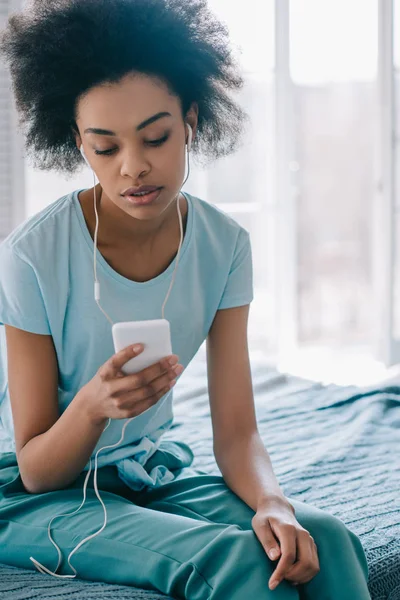 Jong Meisje Zittend Bed Luisteren Naar Muziek Telefoon — Stockfoto