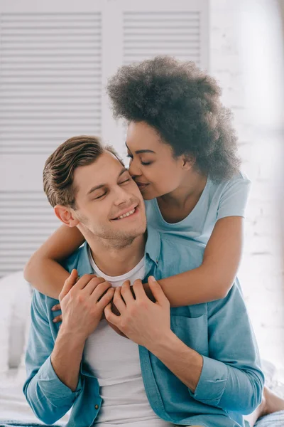 African American Girlfriend Embracing Kissing Man Sitting Bed — Stock Photo, Image