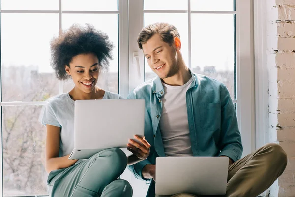 Multiracial Boyfriend Girlfriend Using Laptops While Sitting Window — Stock Photo, Image