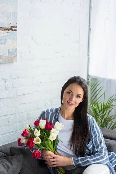 Portret Van Lachende Vrouw Met Boeket Tulpen Zittend Bank Thuis — Stockfoto