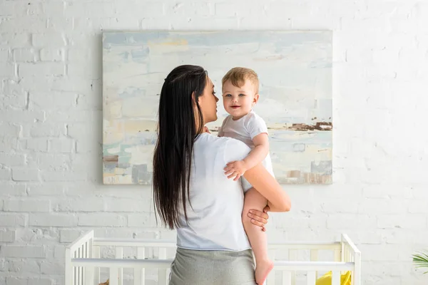 Visão Traseira Mãe Segurando Bebê Sorridente Bonito Mãos Casa — Fotografia de Stock