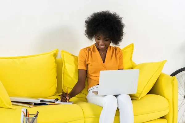 Sorrindo Africano Americano Feminino Freelancer Com Laptop Fazendo Anotações Enquanto — Fotografia de Stock