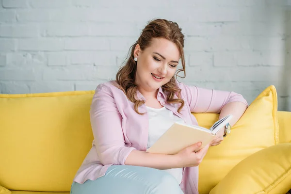 Atractiva Mujer Sonriente Leyendo Libro Sofá Casa — Foto de Stock