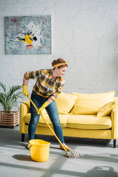 beautiful woman cleaning floor with mop at home