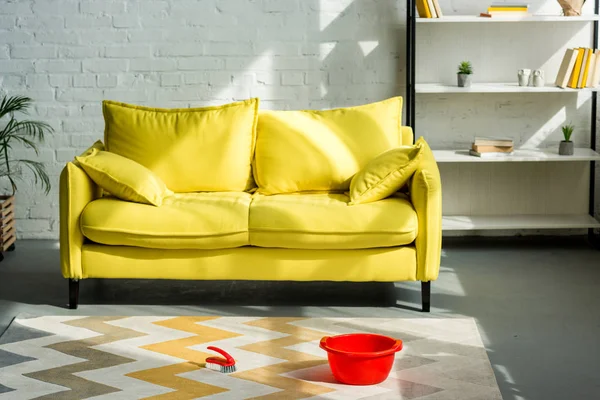 Roter Eimer Und Putzbürste Auf Teppich Boden Gelbes Sofa Wohnzimmer — Stockfoto