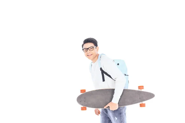 亚洲青少年的侧面观看背包和滑板在白色的隔离 — 图库照片