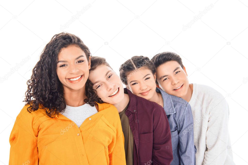 portrait of cheerful multicultural teen friends leaning on each other isolated on white