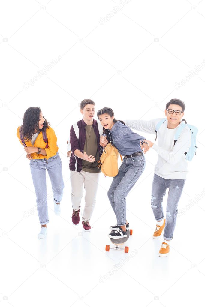 multiracial teenagers with backpacks and skateboard isolated on white