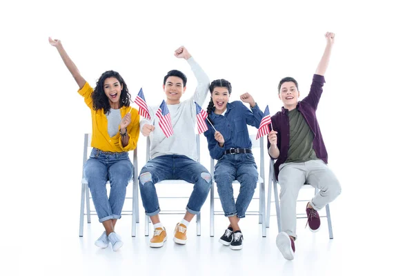 白で隔離の椅子に座っているアメリカのフラグとの十代の学生のグループ — ストック写真