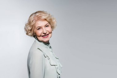 close-up portrait of happy senior woman isolated on grey