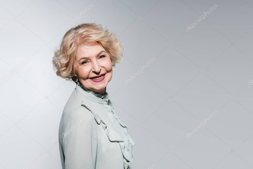 close-up portrait of happy senior woman isolated on grey