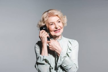 yakın çekim gri yalıtılmış bağbozumu telefonla konuşurken gülümseyen kadın kıdemli portresi