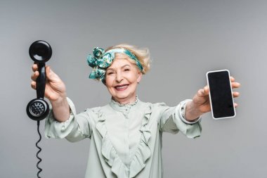 vintage telefon ve smartphone gri izole elinde ile gülümseyen kadın kıdemli