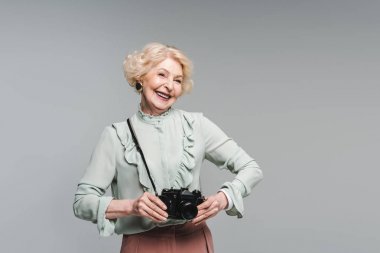 mutlu kadın kıdemli gri izole vintage film kamera ile