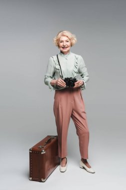 güzel kadın kıdemli Grey vintage çanta ve film kamera ile