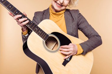 şık kadın akustik gitar bej renkli arka plan üzerinde izole çalmaya kırpılmış görüntü 