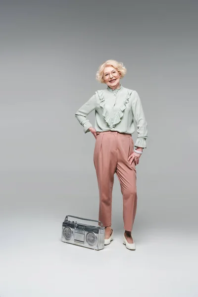 Élégant Senior Femme Avec Boombox Vintage Isolé Sur Gris — Photo gratuite