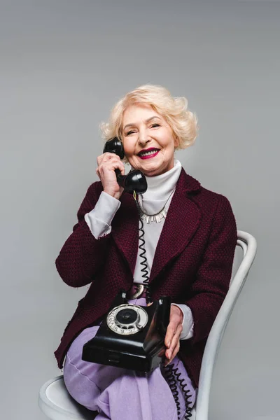 快乐高级时尚女人坐在椅子上 用转盘电话交谈 — 图库照片