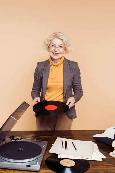 Elegante Mujer Mayor Sosteniendo Disco Vinilo Cerca Mesa Con Reproductor — Foto de Stock