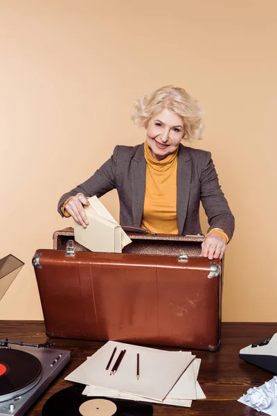 Stylish Senior Woman Putting Books Vintage Suitcase Table Record Player — Free Stock Photo