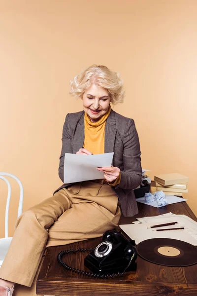 Stylish Senior Woman Writing Paper Sitting Table Rotary Phone Vinyl — Free Stock Photo