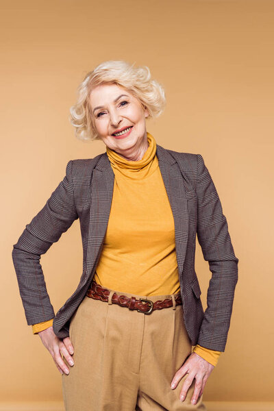 stylish senior woman posing isolated on beige background 