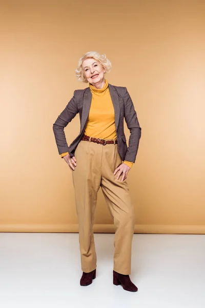 Smiling Fashionable Senior Woman Posing Beige — Free Stock Photo