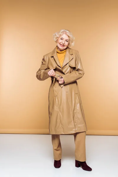 Fashionable Senior Woman Tying Belt Leather Trench Coat — Stock Photo, Image