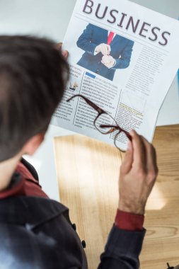 işadamı gazete ofisinde okuma gözlük ile yüksek açılı görünüş