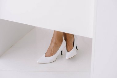 Afro-Amerikan işkadını Office beyaz ayakkabı masada oturan Resim kırpılmış
