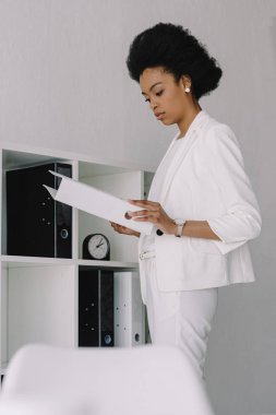 çekici Afro-Amerikan işkadını klasör belgeler ile ofiste holding