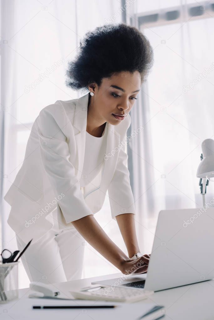 attractive african american businesswoman using laptop in office